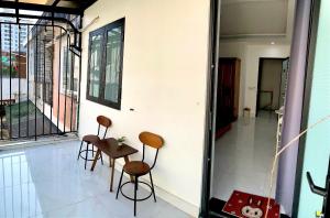 Zimmer mit 2 Stühlen und einem Tisch auf dem Balkon in der Unterkunft Win House Huế in Thôn Dương Phẩm