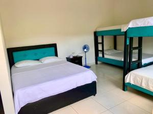 a bedroom with two bunk beds and a mirror at Finca Tres Potrillos Villeta in Villeta