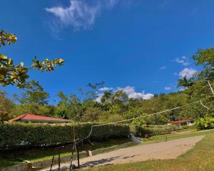 a park with a fence and trees and a blue sky at Finca Tres Potrillos Villeta in Villeta +5 photos