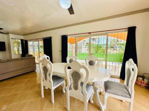 a dining room with a white table and chairs at Villa Tropical Cabarete in Sosua