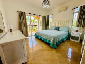 a bedroom with a bed and a large window at Villa Tropical Cabarete in Sosua +16 photos