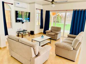 a living room with two couches and a tv at Villa Tropical Cabarete in Sosua