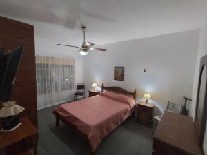 een slaapkamer met een bed en een plafondventilator bij Ziegler House in Concepción del Uruguay