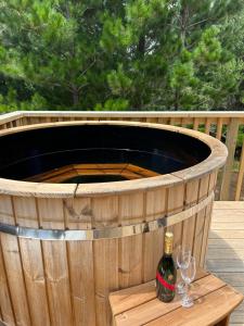 a barrel with a bottle of wine and glasses on a table at Kauri Cabins Tranquil Retreat in Whitianga