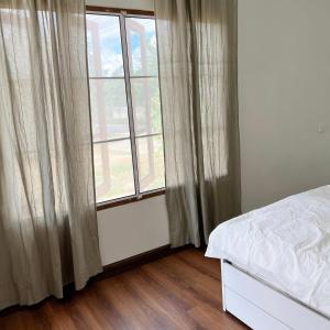 a bedroom with a bed and a large window at Prachanngam Homestay in Ban Sam Laem