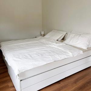 a white bed with white sheets and pillows at Prachanngam Homestay in Ban Sam Laem