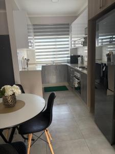 een keuken met een tafel en een aantal stoelen en een tafel bij Haven & Beyond in Gaborone