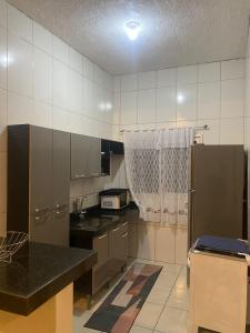 a kitchen with stainless steel cabinets and a refrigerator at Casa completa com dois quartos e estacionamento grátis in Serra +6 photos