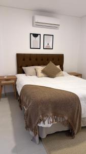 a bedroom with a large bed with a brown blanket at Lujoso Apartamento en edificio frente a la playa San José! in Encarnación +18 photos