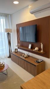 a living room with a large television on a wall at Lujoso Apartamento en edificio frente a la playa San José! in Encarnación