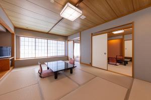 een woonkamer met een tafel en stoelen in een kamer bij Higaki Hotel in Gamagori