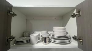 a cabinet filled with plates and cups and a toilet at Departamento Liss in Mérida