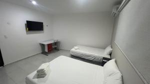 a hospital room with two beds and a tv at Departamento Liss in Mérida