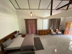 a bedroom with a bed and a couch and a chair at 108 Palms Beach Resort in Trincomalee