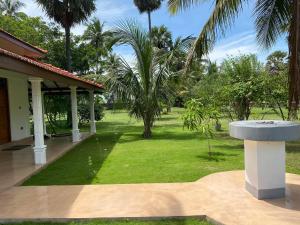 a garden with a fountain in front of a house at 108 Palms Beach Resort in Trincomalee +147 photos