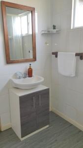 een badkamer met een wastafel en een spiegel bij Cabaña en Frutillar in Frutillar