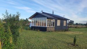 een klein huis in het midden van een veld bij Cabaña en Frutillar in Frutillar
