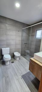 een badkamer met een toilet, een wastafel en een douche bij Departamentos Hilario Lagos in Viedma