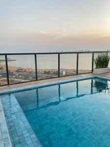 a swimming pool with a view of the ocean at Lujoso Apartamento en edificio frente a la playa San José! in Encarnación