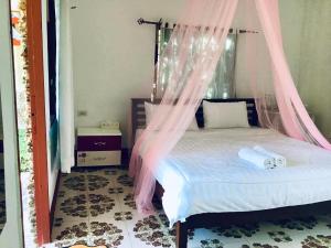 a bedroom with a bed with a mosquito net at DoiLom Farmstay in Ban Muang Kut