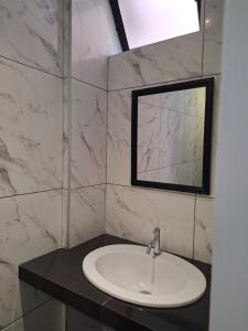 een badkamer met een wastafel en een spiegel bij Montemar Apart Hotel - Playa Huanchaco in Huanchaco