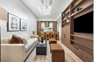 a living room with a couch and a flat screen tv at The Brick Hotel - The Loft in Toronto