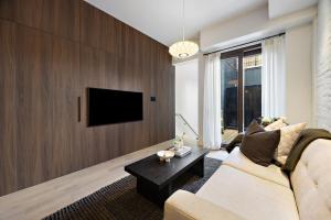 a living room with a couch and a tv at The Brick Hotel - The Second Suite in Toronto