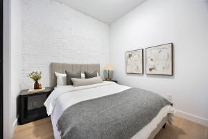 a bedroom with a large bed with white walls at The Brick Hotel - The Second Suite in Toronto