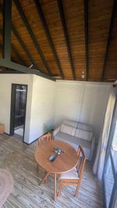 a table and chairs in a room with a couch at Novidade-Cabana Praia do Rosa in Imbituba