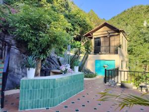 a house with a blue door and a building at Catba Garden Camellia in Cat Ba