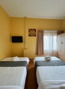 een hotelkamer met twee bedden en een televisie bij I Talay phuket in Karon Beach