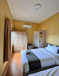 een slaapkamer met een groot bed en een koelkast bij I Talay phuket in Karon Beach