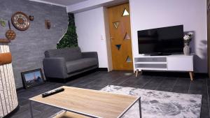 een woonkamer met een televisie en een bank bij Cozy apartment in Heiligenrode in Niestetal