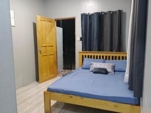 a bedroom with a blue bed with a wooden headboard at LIBYA's Guesthouse in San Juan