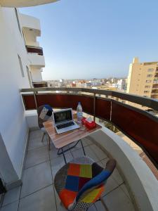 a balcony with a table with a laptop on it at STUDIO NGOR ALAMADIES BAKU plus in Dakar