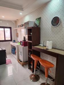a kitchen with a counter and a stool in it at STUDIO NGOR ALAMADIES BAKU plus in Dakar +11 photos
