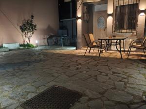 a patio with a table and chairs and a grate at Xryspa suites in Ioannina