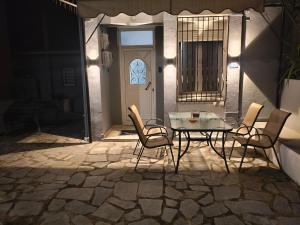 a patio with a table and chairs in front of a door at Xryspa suites in Ioannina