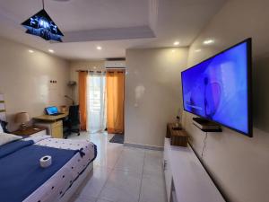 a bedroom with a large flat screen tv on the wall at STUDIO NGOR ALAMADIES BAKU plus in Dakar