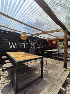 een houten terras met een houten tafel en banken bij Wood Side Hostel in Mar del Plata +54 foto's
