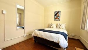 una camera da letto con un letto e un grande specchio di Long Street Backpackers a Città del Capo
