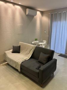 a bed in a room with a couch and a table at Atalaia Apart in Sinop