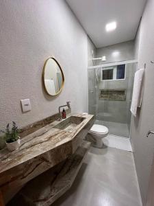 a bathroom with a sink and a toilet and a mirror at Atalaia Apart in Sinop