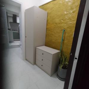 a room with a white cabinet and a yellow wall at Earth House HomeStay Bangjo in Ban Pak Lak