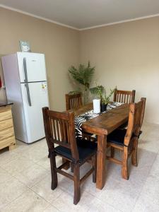a kitchen with a wooden table with chairs and a refrigerator at Complejo Génesis in San José