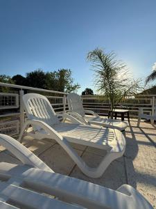 two white chairs sitting on top of a deck at Complejo Génesis in San José