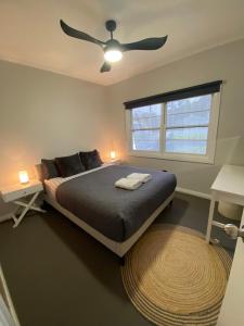 una camera da letto con un letto e un ventilatore a soffitto di 2 Long between breaks a Coffs Harbour Altre 38 foto