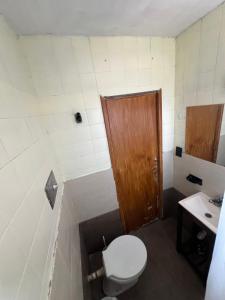 a bathroom with a toilet and a sink at Polimar in Mar de Ajó +1 photo