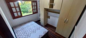 a small room with a bed and a window at Chácara mobiliada próximo Criciúma Br101 in Araranguá