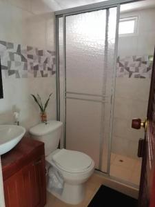 a bathroom with a toilet and a glass shower at Casa Lucy in Yumbo +12 photos